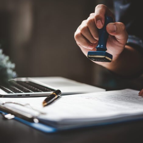 home-1 Man stamping approval of work finance banking or investment marketing documents on desk.